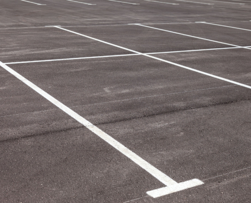 White traffic markings on a gray asphalt parking lot