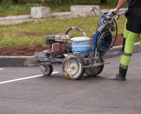 Worker painting lines on parking lot